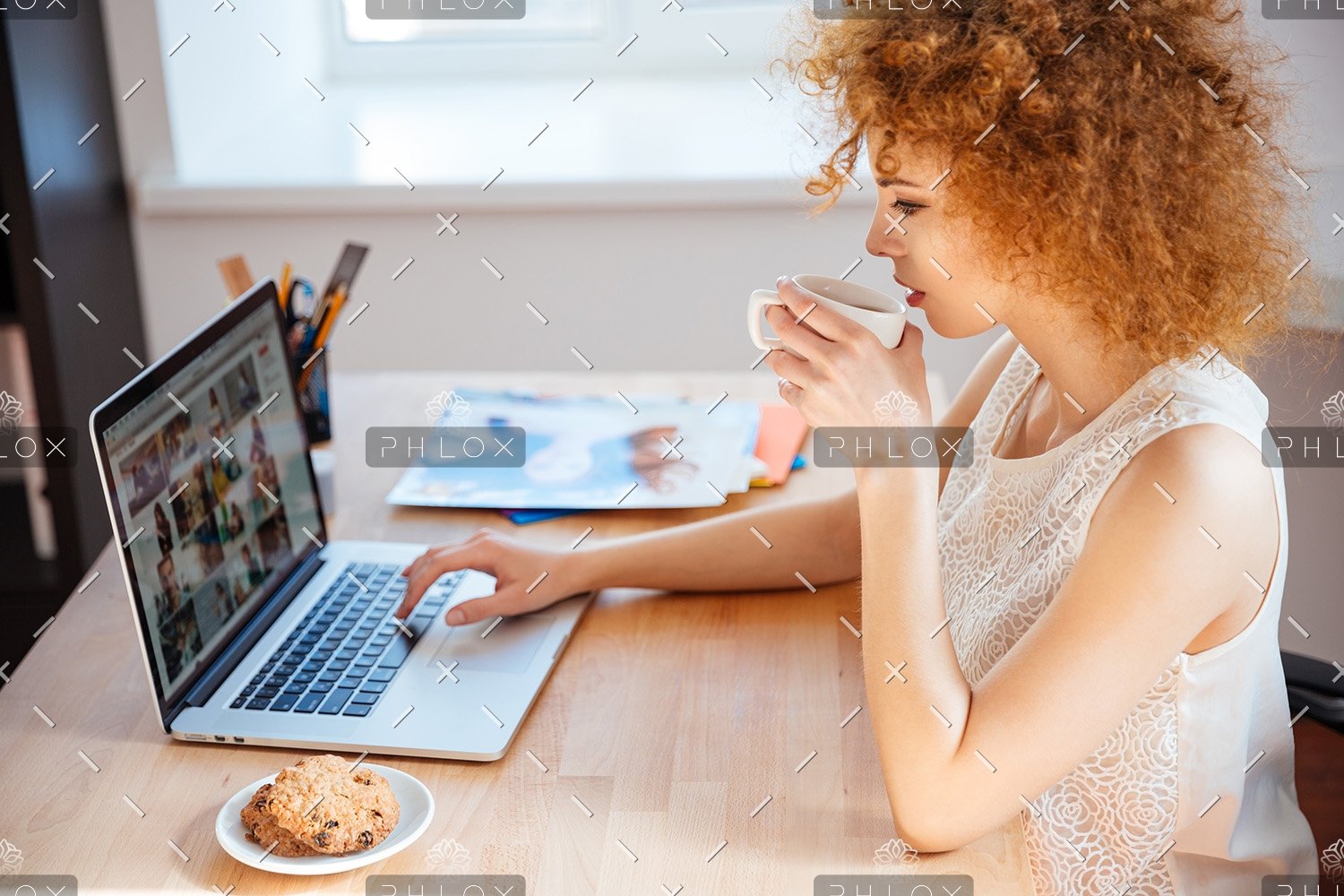 woman-photographer-drinking-coffee-and-working-PJNBP6U-2